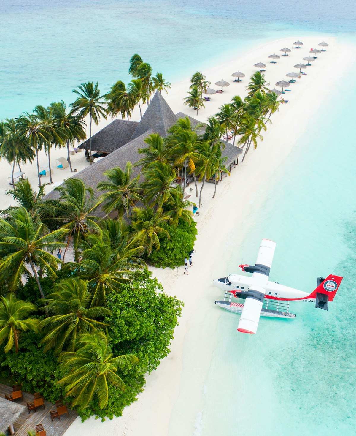 Family on a Maldives holiday enjoying crystal-clear water and white sand beach