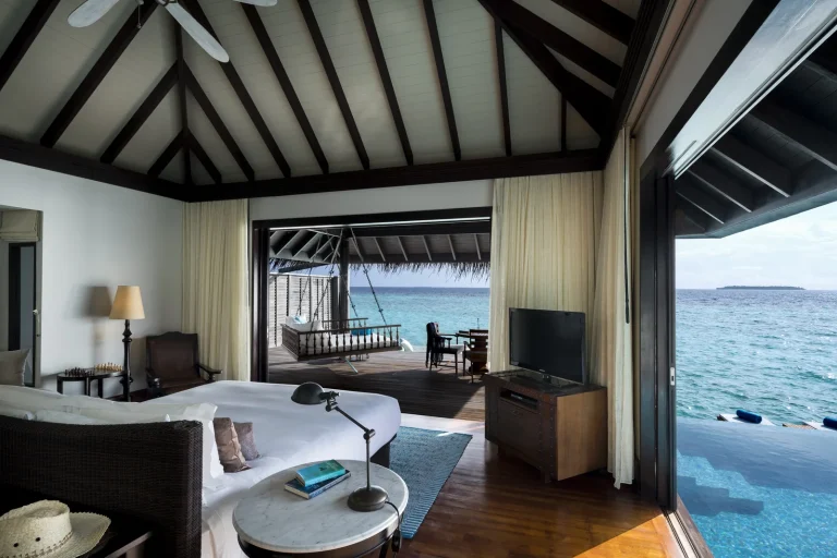 Bedroom of an Anantara Kihavah Over Water Pool Villa opening onto a private deck and pool above the lagoon, Baa Atoll, Maldives