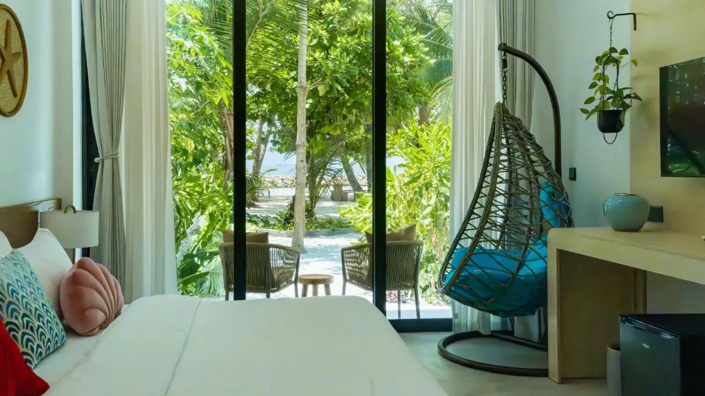 Bedroom with a bed and a large window at Biosphere Beach, Dharavandhoo, Maldives