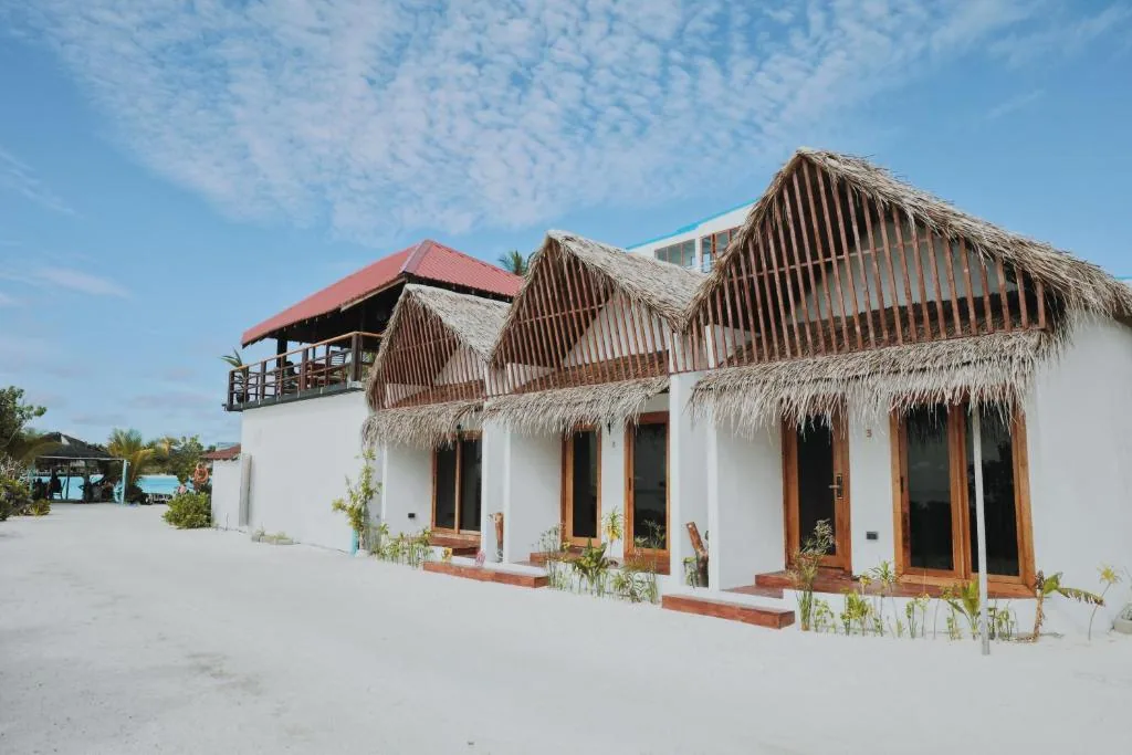 Thatched-roof bungalows with wooden verandas and sliding doors on white sand, numbered 2 and 3, near the ocean at Club Kaafu, Dhiffushi, Maldives