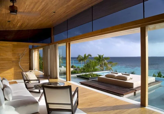 Open living room of the Palm Residence with timber ceiling, glass walls and a pool deck facing the ocean, Coco Privé Kuda Hithi, North Malé Atoll, Maldives