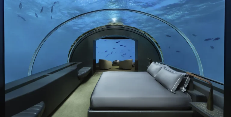 King bed in an underwater bedroom beneath a curved acrylic dome with fish outside, The Muraka, Conrad Maldives Rangali Island