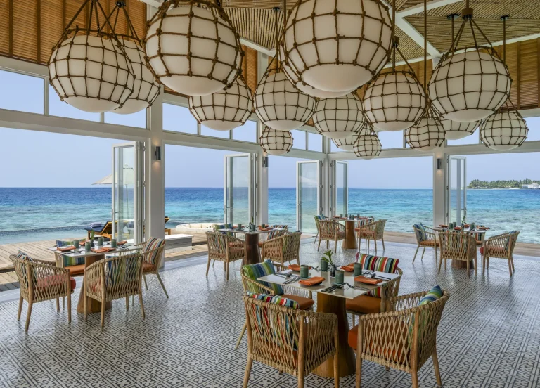 Overwater dining room with woven pendant lights and ocean views at Yuzu, The Halcyon Private Isles Maldives