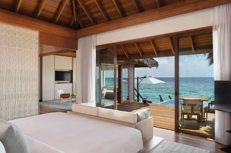 Overwater bedroom opening onto a deck with an infinity pool and the ocean, Huvafen Fushi, Maldives