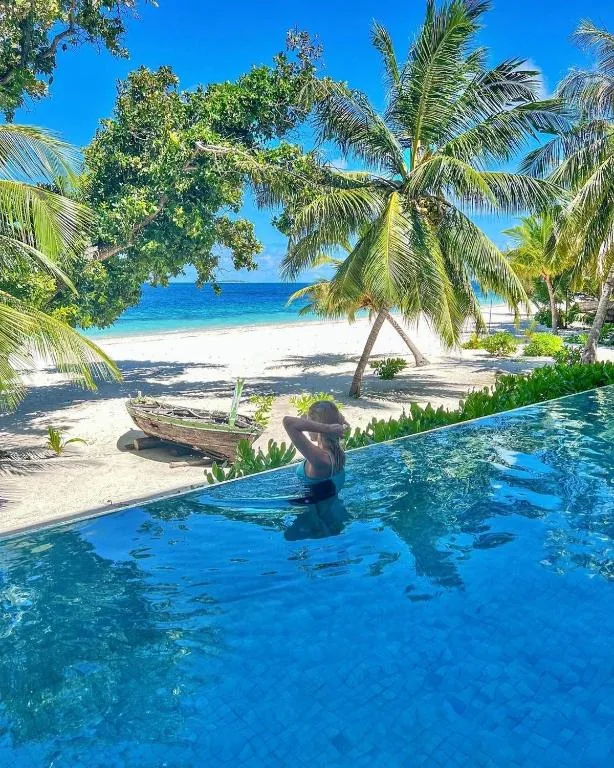 Person in a swimming pool next to a beach at Kiha Beach, Dharavandhoo, Maldives