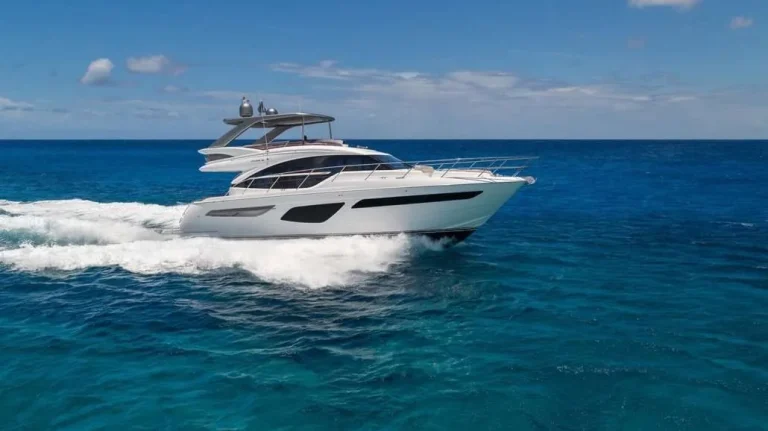 White luxury motor yacht cruising across deep blue water near Kudadoo Maldives Private Island