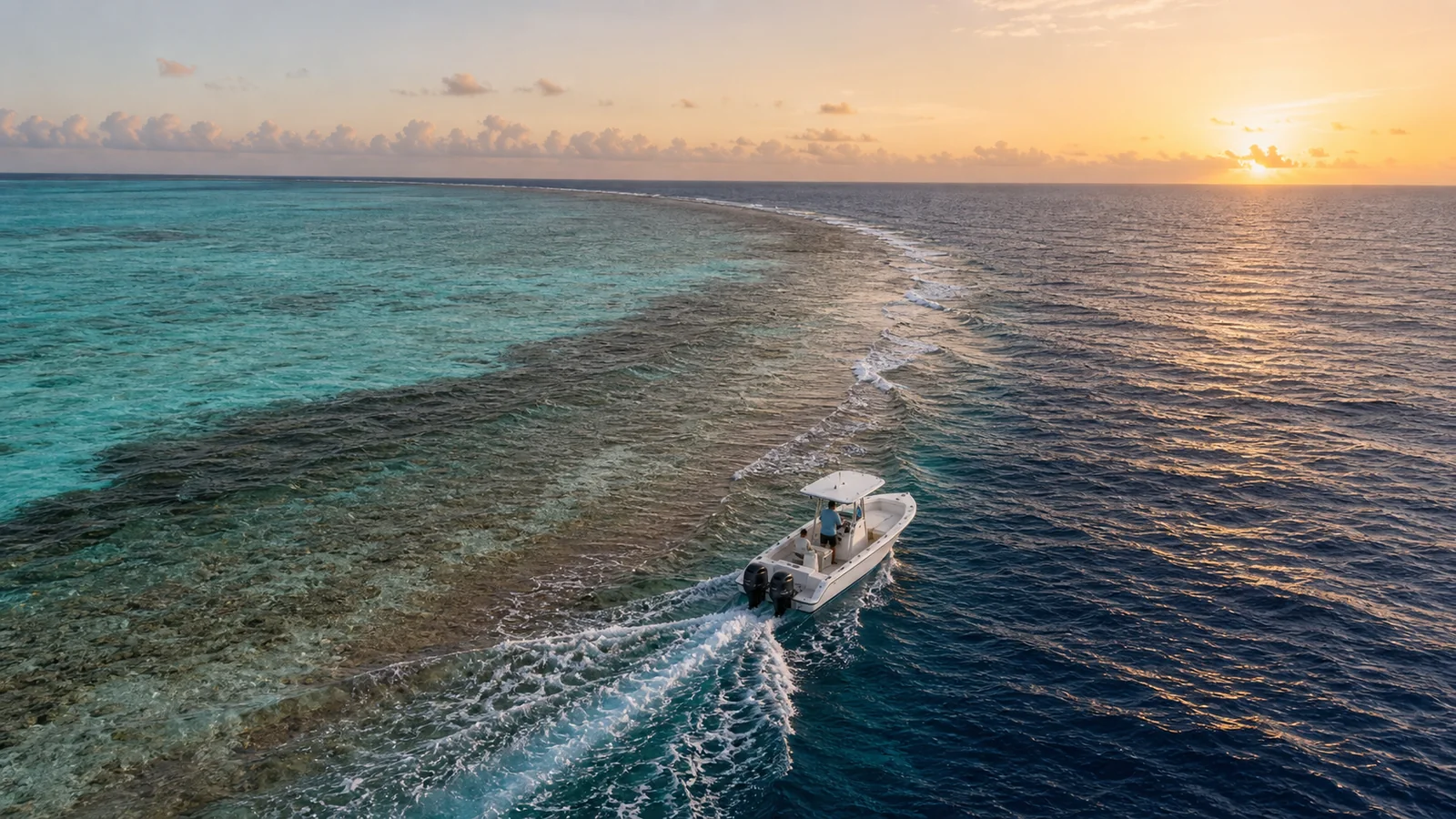 Sport fishing vessel crossing the reef edge of Laamu Atoll at sunrise, southern Maldives