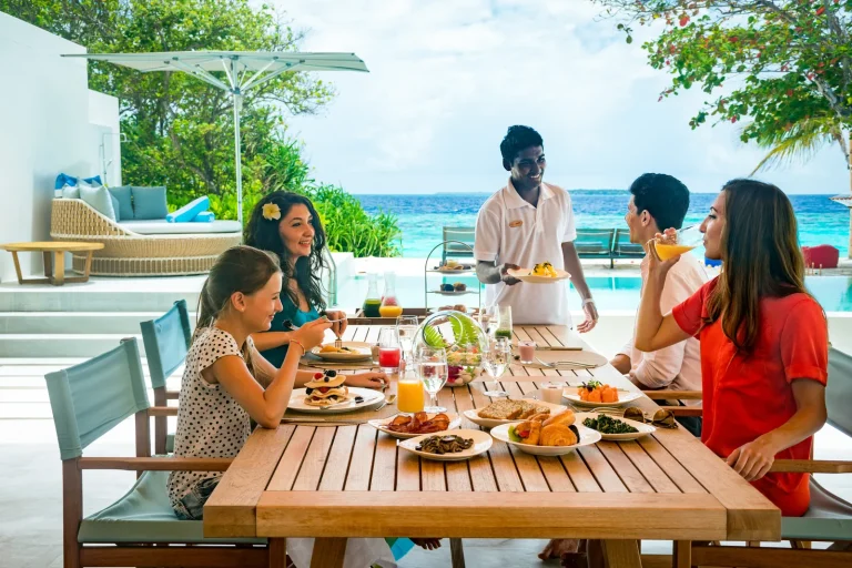 A family having lunch on the terrace of a residence at Amilla Maldives, Baa Atoll