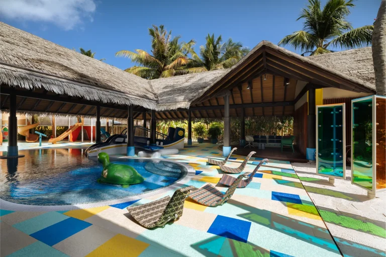 Colourful children's water park with slides and splash pool at the Lha Velaa kids club under thatched roofs, Velaa Private Island, Noonu Atoll