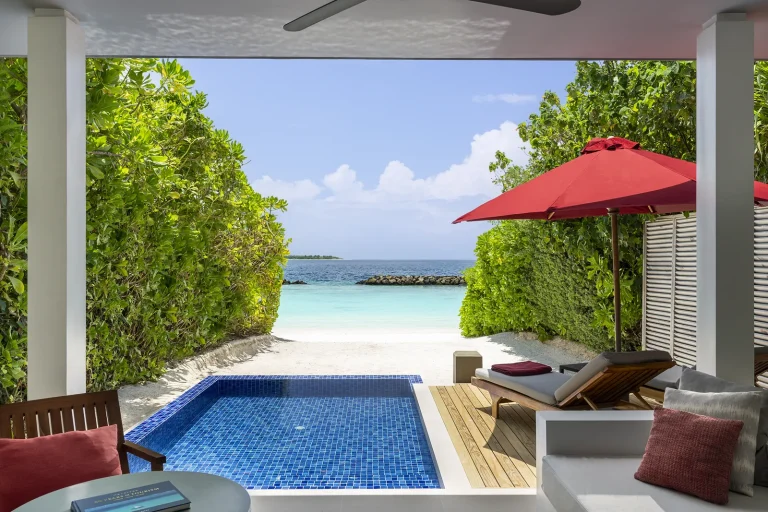 Beach Villa with Pool with a blue plunge pool, red parasol and loungers opening onto the beach at Niva Dhigali Maldives, Raa Atoll