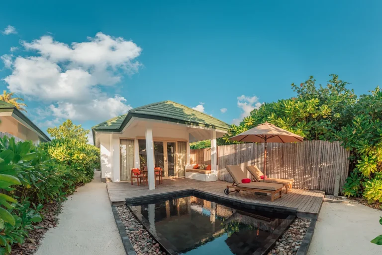 Sunset Pool Beach Villa with a dark-tiled private pool, sun lounger and garden path at Siyam World Maldives, Noonu Atoll