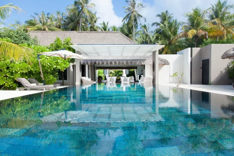 One-bedroom Island Villa with a long private pool and white pavilion among palms at Cheval Blanc Randheli, Noonu Atoll, Maldives