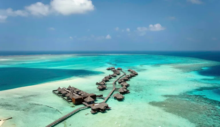Aerial view of Conrad Maldives Rangali Island with jetties of overwater villas and beach villas across a turquoise lagoon, South Ari Atoll