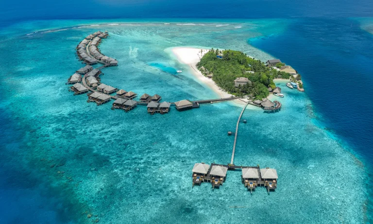 Aerial view of Adaaran Prestige Vadoo island with a crescent of overwater villas on a jetty over the reef, South MalΓ© Atoll, Maldives