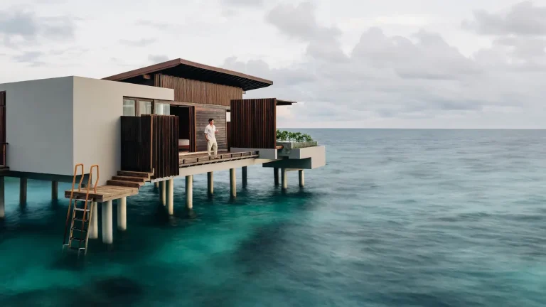Timber and glass overwater villa on stilts with a ladder into clear reef water at Park Hyatt Maldives Hadahaa, Gaafu Alifu Atoll, Maldives