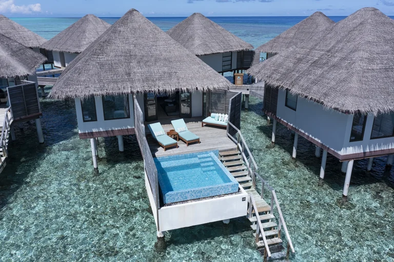 Thatched water bungalows with private plunge pools and steps down to the lagoon at Velassaru, South MalΓ© Atoll, Maldives