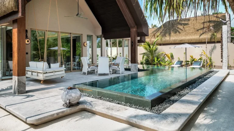 Two-bedroom beach pool villa with a long rectangular private pool, loungers and timber deck under palms at JOALI BEING, Raa Atoll, Maldives