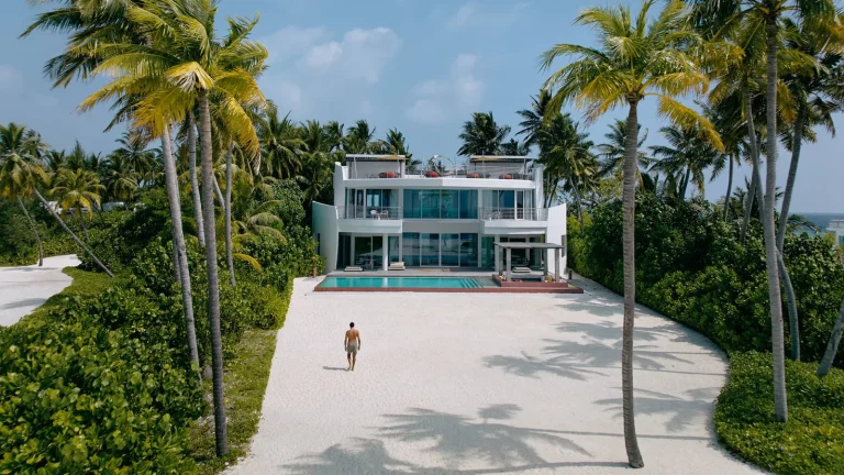 Two-storey white beach villa with a long private pool and rooftop terrace facing a sandy path and palms at Jumeirah Olhahali Island, North MalΓ© Atoll, Maldives