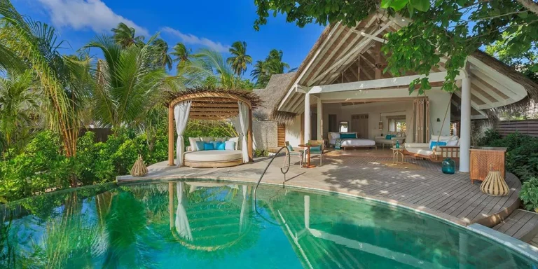 Beach Pool Villa with a curved private pool, thatched sala and timber deck under palms at Milaidhoo Maldives, Baa Atoll