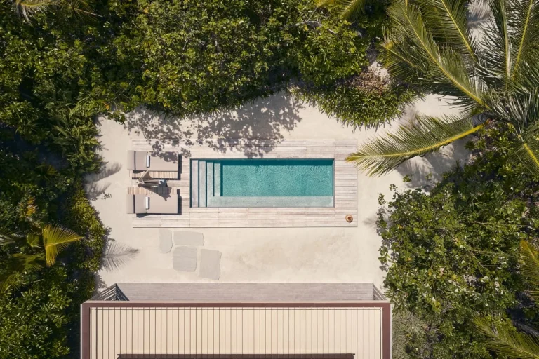 Top-down view of a Patina Maldives One Bedroom Beach Pool Villa with a rectangular private pool, loungers and timber deck in the garden, Fari Islands, North MalΓ© Atoll