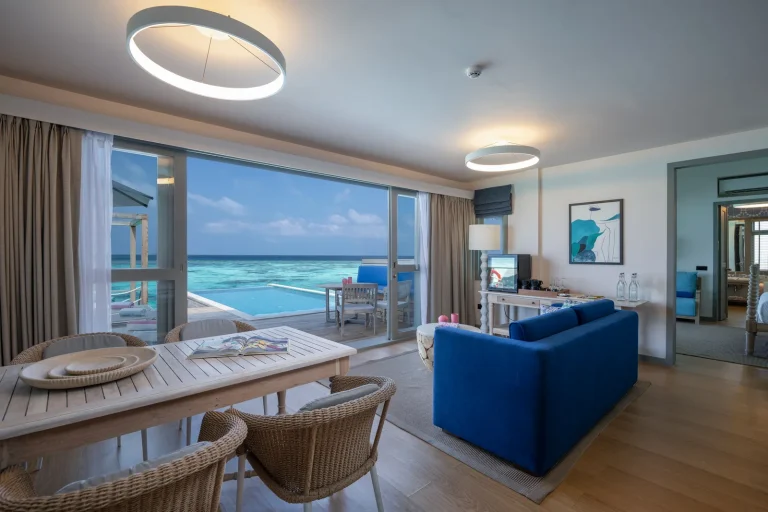 The downstairs living room of a Two Bedroom Lagoon Pool Villa with Slide at Cora Cora Maldives, opening to the lagoon