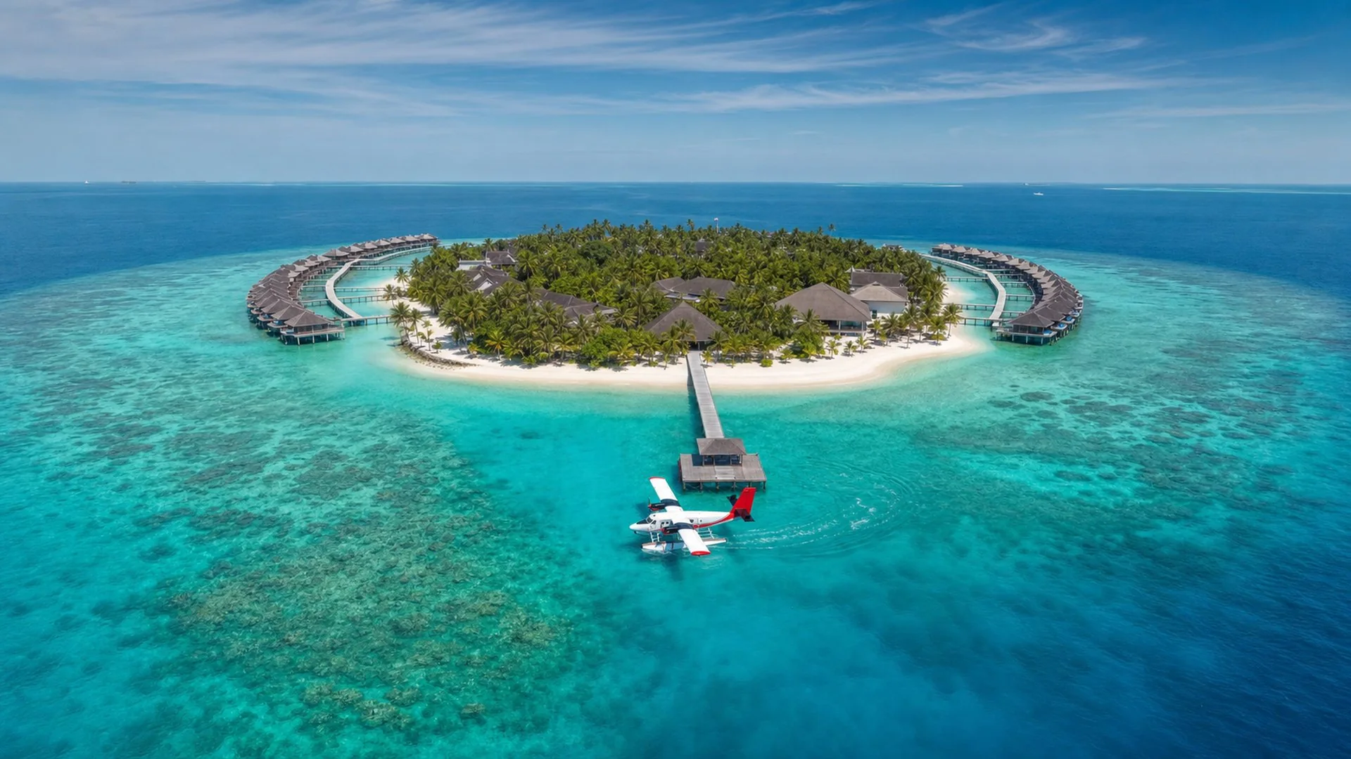 Aerial view of a maldives resort island with a seaplane on the lagoon