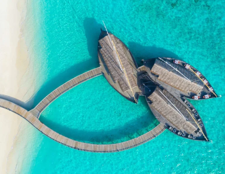 Aerial view of a restaurant shaped like three traditional boats over a turquoise lagoon, Baβtheli, Milaidhoo Maldives, Baa Atoll, Maldives