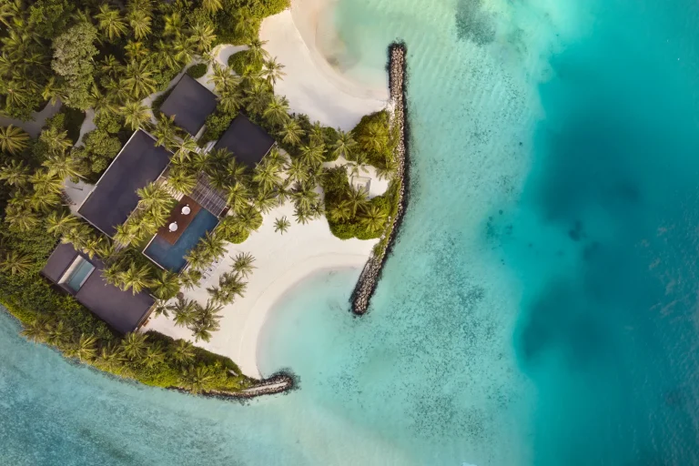 Top-down aerial of The Ritz-Carlton Estate, four Kerry Hill-designed pavilions with a long infinity pool on a private beach point, Fari Islands, North MalΓ© Atoll