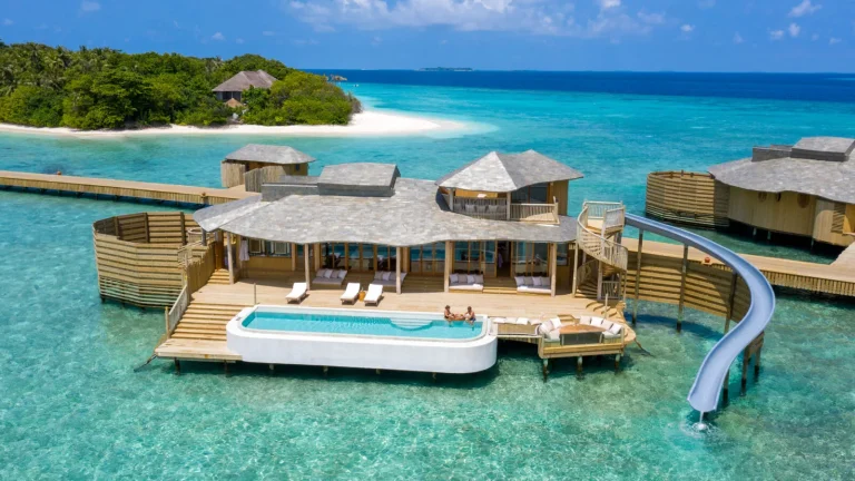 Soneva Fushi one-bedroom Water Retreat with thatched roof, private pool, sun deck and water slide over a turquoise lagoon, Baa Atoll, Maldives