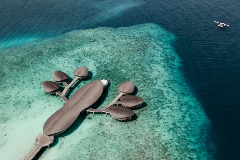 Aerial view of the Iridium Spa at The St. Regis Maldives Vommuli Resort, a sculpted overwater spa on a jetty above the reef edge in Dhaalu Atoll