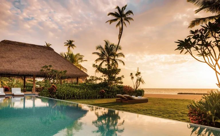 Infinity pool and lawn of the three-bedroom beach villa on Ithaafushi Private Island at sunset, Waldorf Astoria Maldives Ithaafushi, South MalΓ© Atoll