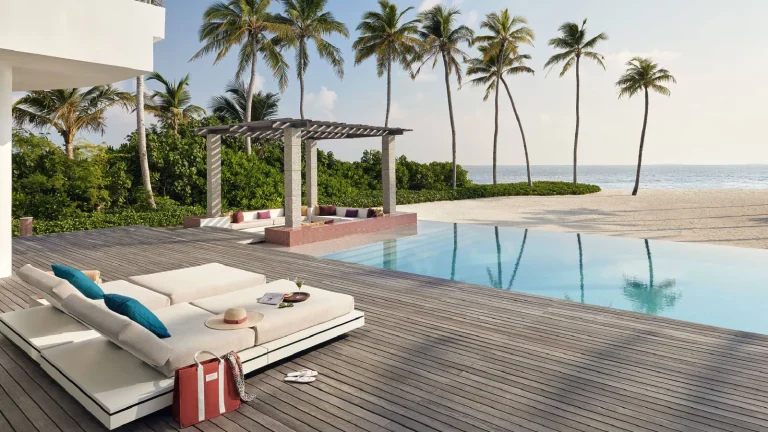 Pool deck and loungers of the Three Bedroom Olhahali Beach Retreat with palms and the lagoon beyond, Jumeirah Olhahali Island, North MalΓ© Atoll