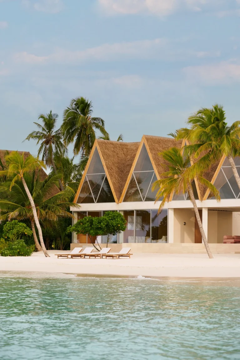 Pitched-roof beachfront villa among palms above a clear shallow lagoon, Nilaa Coral Island, Gaafu Dhaalu Atoll, Maldives