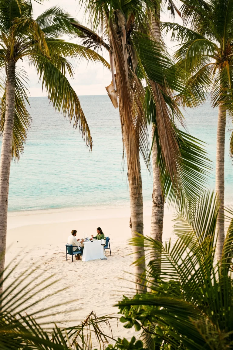 Nilaa Coral Island, Gaafu Dhaalu Atoll, Maldives: couple at a sandbank picnic under palms