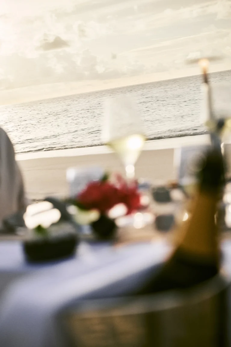 Table set with flowers and Champagne on a sunny villa terrace, Nilaa Coral Island, Maldives