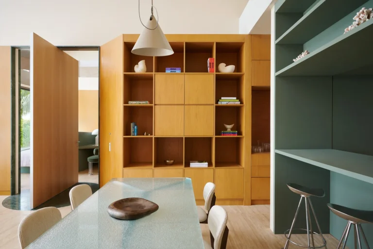 Villa kitchen with timber cabinets, a glass dining table and bar stools, Nilaa Coral Island, Maldives