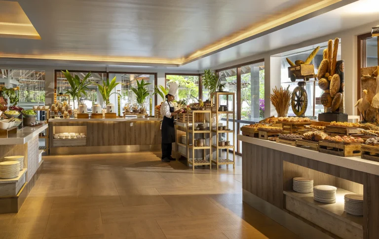 Bakery counter piled with breads, croissants and pastries in a bright restaurant at Niva Dhigali Maldives