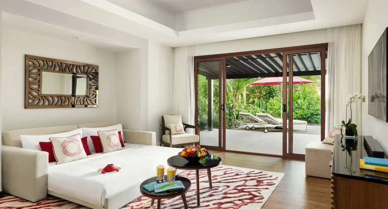 Living room of a family beach pool villa with a sofa bed made up for children and doors open to the garden at Niyama Private Islands, Maldives