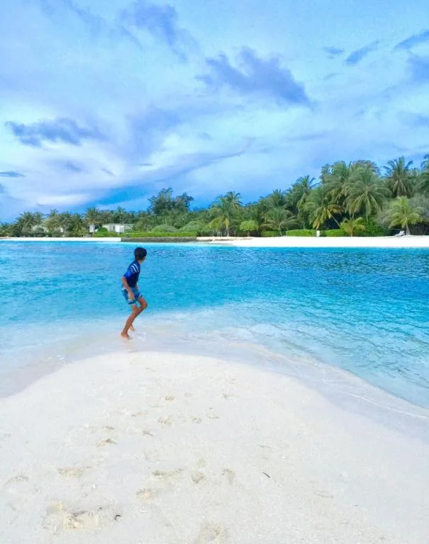 Un hombre parado en una playa en el agua en Ocean Way Guraidhoo, en Guraidhoo at Ocean Way Guraidhoo, Guraidhoo, Maldives
