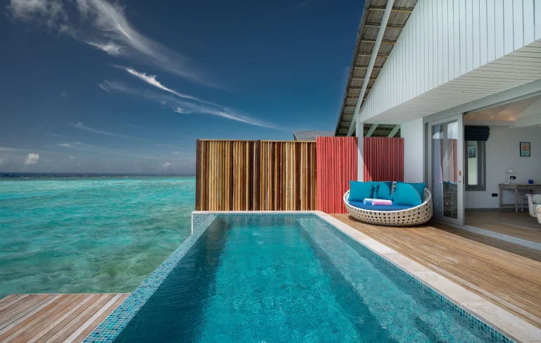 Overwater Lagoon Pool Villa terrace with a long infinity pool, sun loungers and steps into the turquoise lagoon at Cora Cora Maldives, Raa Atoll