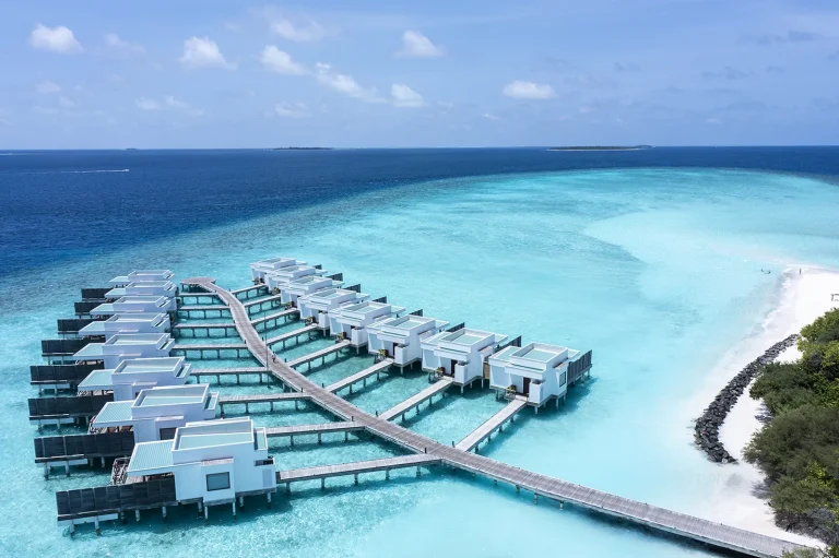 Aerial view of the Lagoon Villas with Pool on a long jetty over a turquoise lagoon at Niva Dhigali Maldives, Raa Atoll