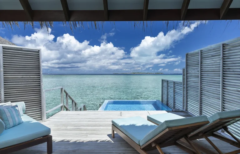 Pool deck of a Velassaru Water Bungalow with a plunge pool, loungers and steps to the lagoon, South MalΓ© Atoll, Maldives