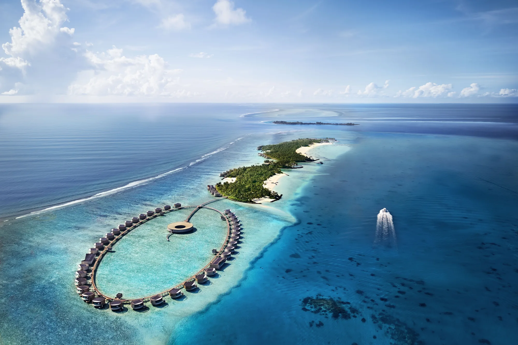 Aerial view of a circle of overwater villas off a palm-covered island in deep blue sea at The Ritz-Carlton Maldives, Fari Islands