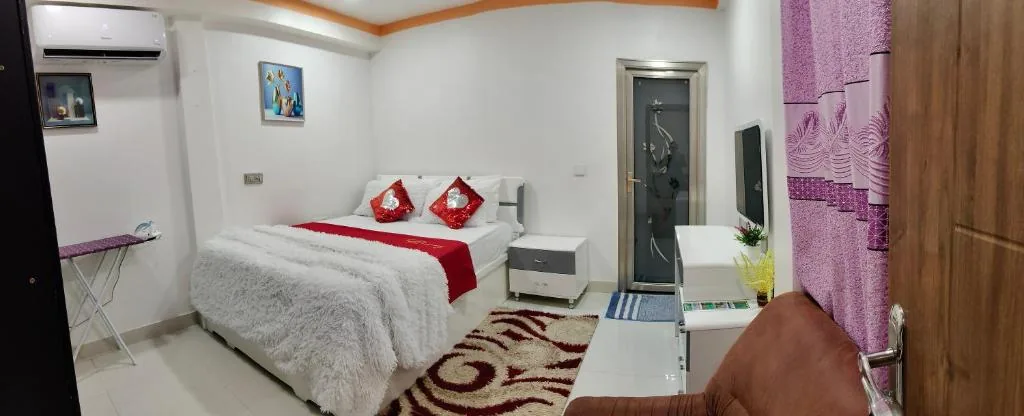 Bedroom with a bed with red pillows on it at Save Sweet Home, Fuvahmulah, Maldives